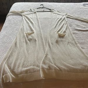 Free People long sweater with long sleeves and pockets. Longer in back.